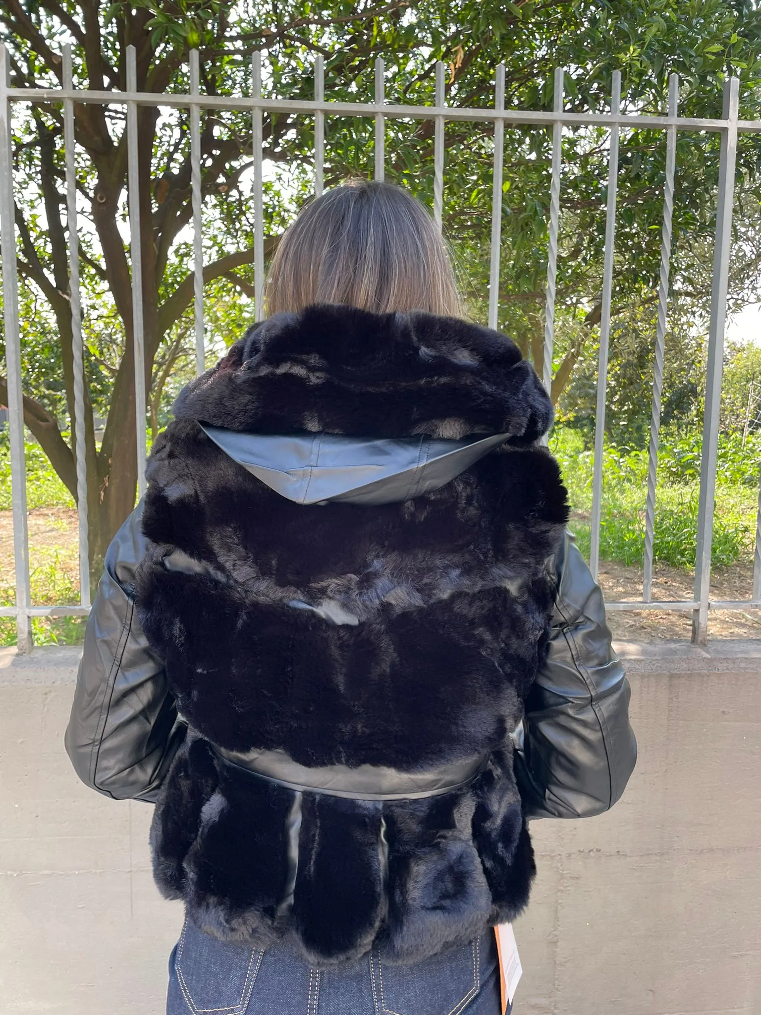 Black fur coat with faux leather sleeves.
